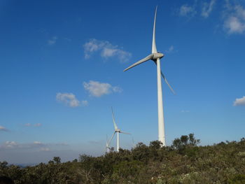 Low angle view of windmill on field against sky