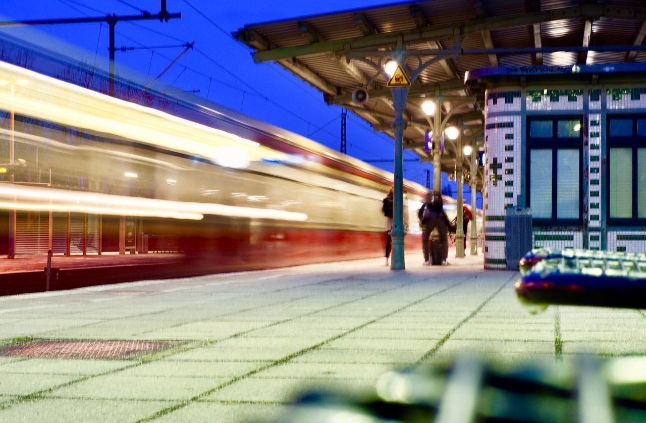 BLURRED MOTION OF TRAIN AT ILLUMINATED RAILROAD STATION