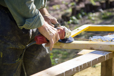 Midsection of carpenter working on wood