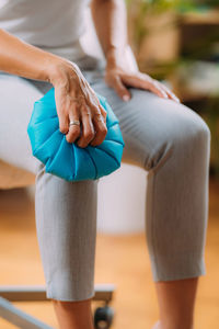 Knee pain treatment. woman holding an ice bag pack on her painful knee