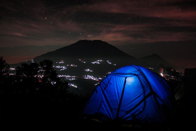 Illuminated tent against sky at night