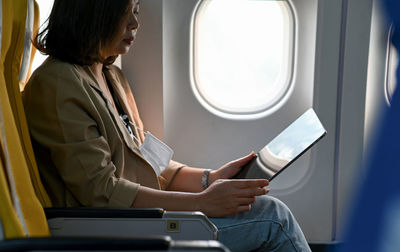 Midsection of man sitting in airplane