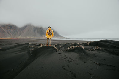 Man on black sand in desert