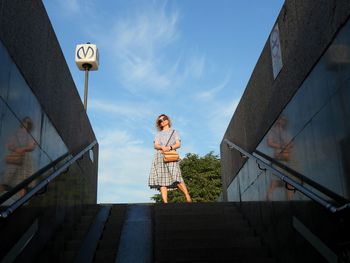 Low angle view of woman standing against building