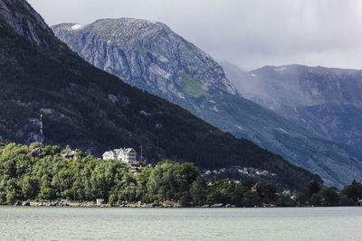 Scenic view of lake by mountains against sky