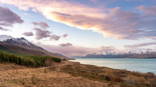 Mount cook road alongside lake pukaki with snow capped southern alps in winter evening light. 