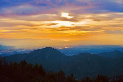 Scenic view of dramatic sky over landscape during sunset