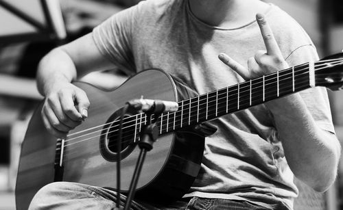 Midsection of man playing guitar