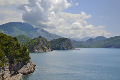 Scenic view of sea and mountains against sky