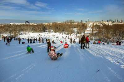 High angle view of people at snow covered landscape against sky