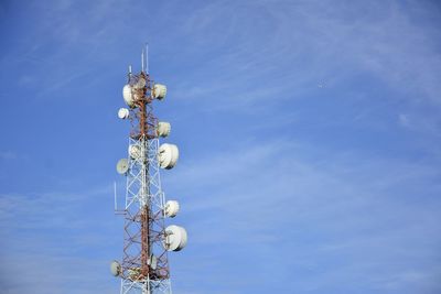 Low angle view of communications tower against blue sky