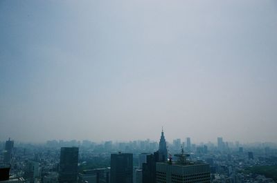 Buildings in city against clear sky