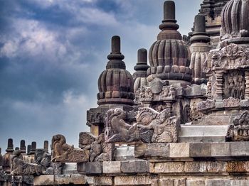 Statue of historic temple against cloudy sky