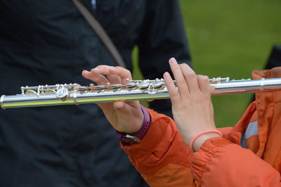 Cropped hands playing musical instrument by man