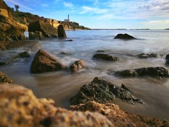 Scenic view of rocks in sea against sky