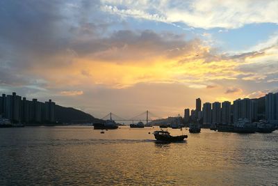 Scenic view of sea and buildings against sky during sunset