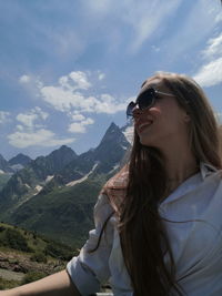 Young woman wearing sunglasses against sky