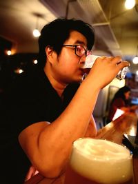 Mid adult man drinking glass in restaurant