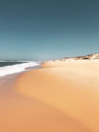 Scenic view of beach against clear blue sky