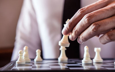 Midsection of businessman playing chess board