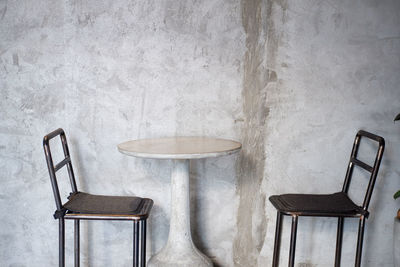 Empty chairs and table against wall at home