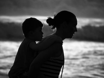 Side view of mother and son at beach