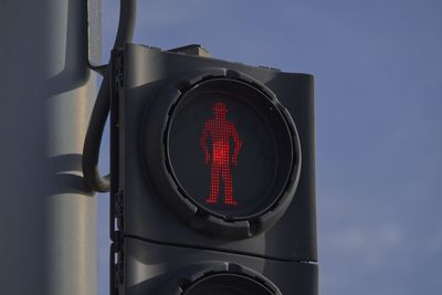 Illuminated red stop man on pedestrian crossing