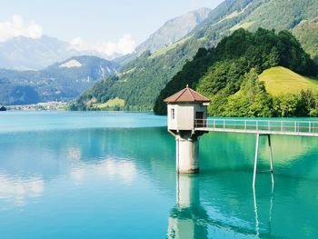 Swimming pool by lake against mountains