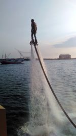 Man standing in sea against sky