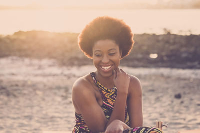 Smiling young woman sitting at beach