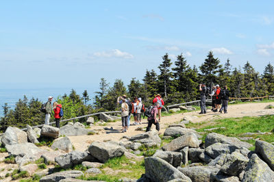 Hikers on mountain against sky at harz national park