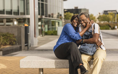 Happy senior couple spending leisure time with each other sitting on bench