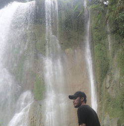 Full length of man against waterfall in forest