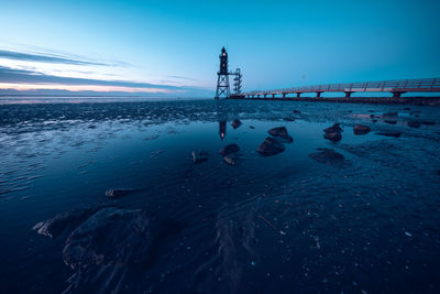 People standing on beach by sea against sky during winter