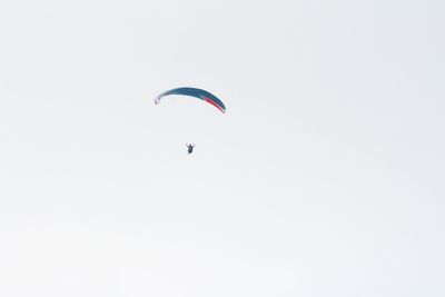 Low angle view of paragliding against clear sky
