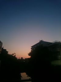 Silhouette trees against clear sky during sunset