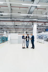 Businesswoman discussing with colleagues in modern industry