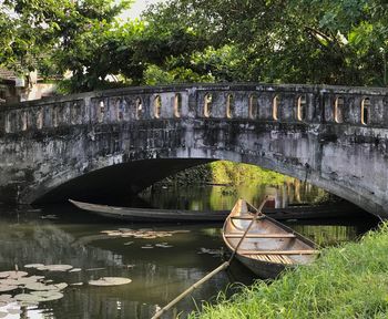 Bridge over canal against trees