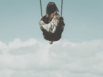 Low angle view of woman standing against sky