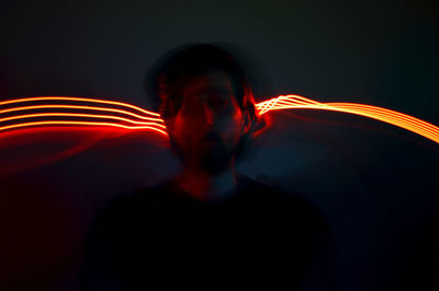 Portrait of light trails against black background