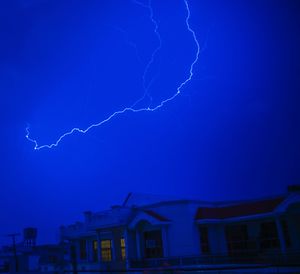 Aerial view of lightning over house against dramatic sky