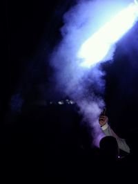 Silhouette woman in illuminated stage at night