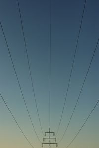 Low angle view of power lines against clear blue sky