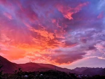 Scenic view of dramatic sky over silhouette landscape