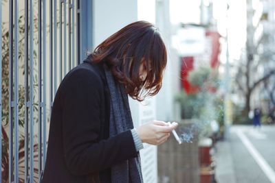 Woman using smart phone in city
