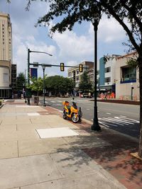 Cars on street by buildings against sky