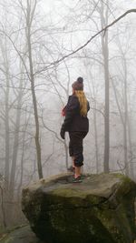Rear view of woman standing in forest