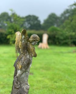 Close-up of angel sculpture on field