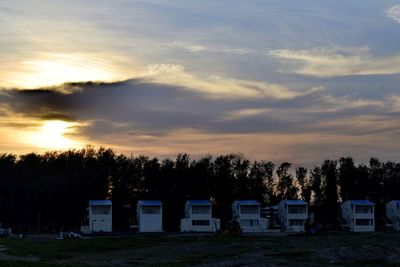 Built structure on field against sky at sunset