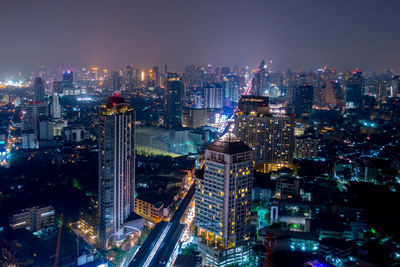 Illuminated cityscape against sky at night